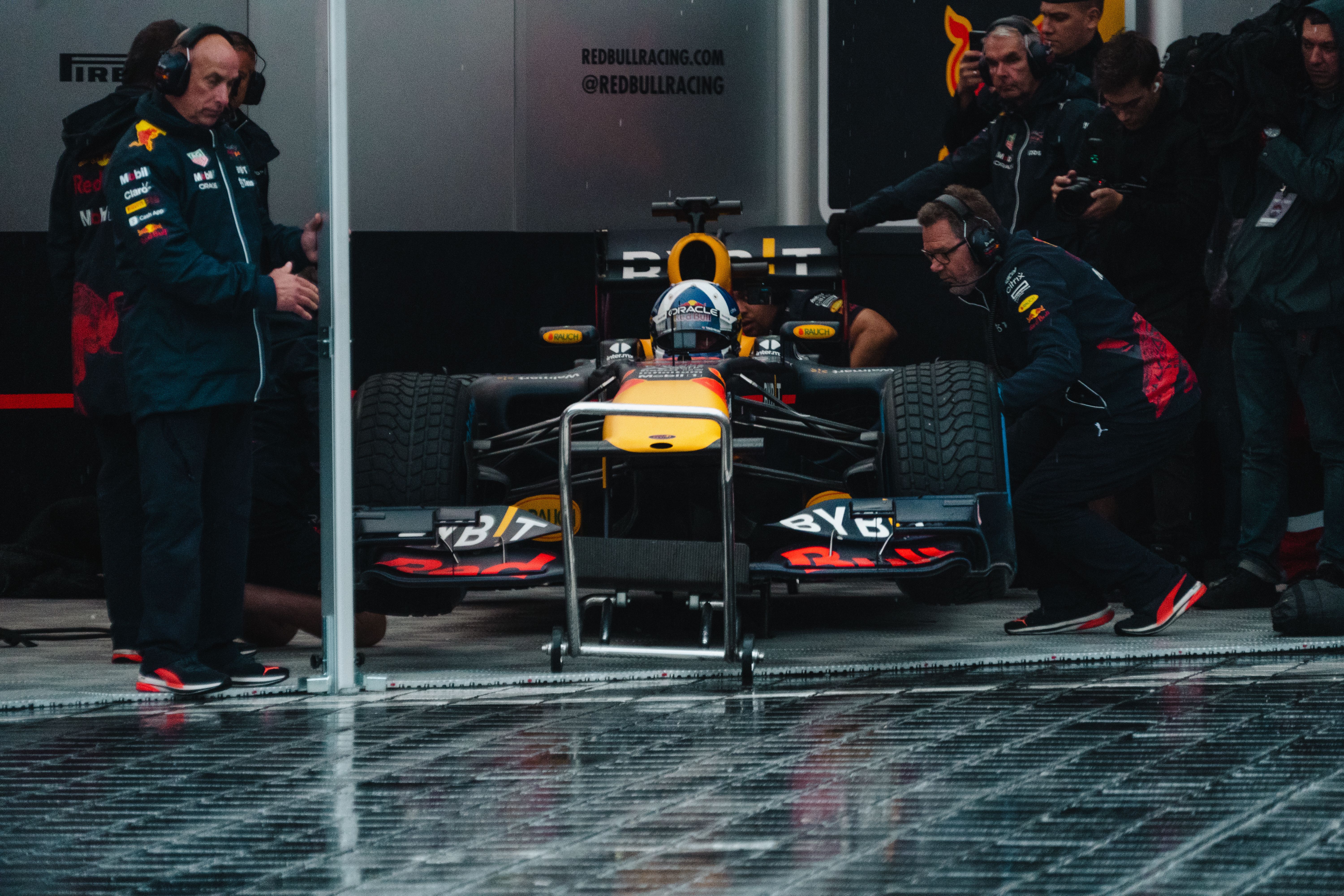 Formula 1 pit crew servicing a race car during a fast pit stop
