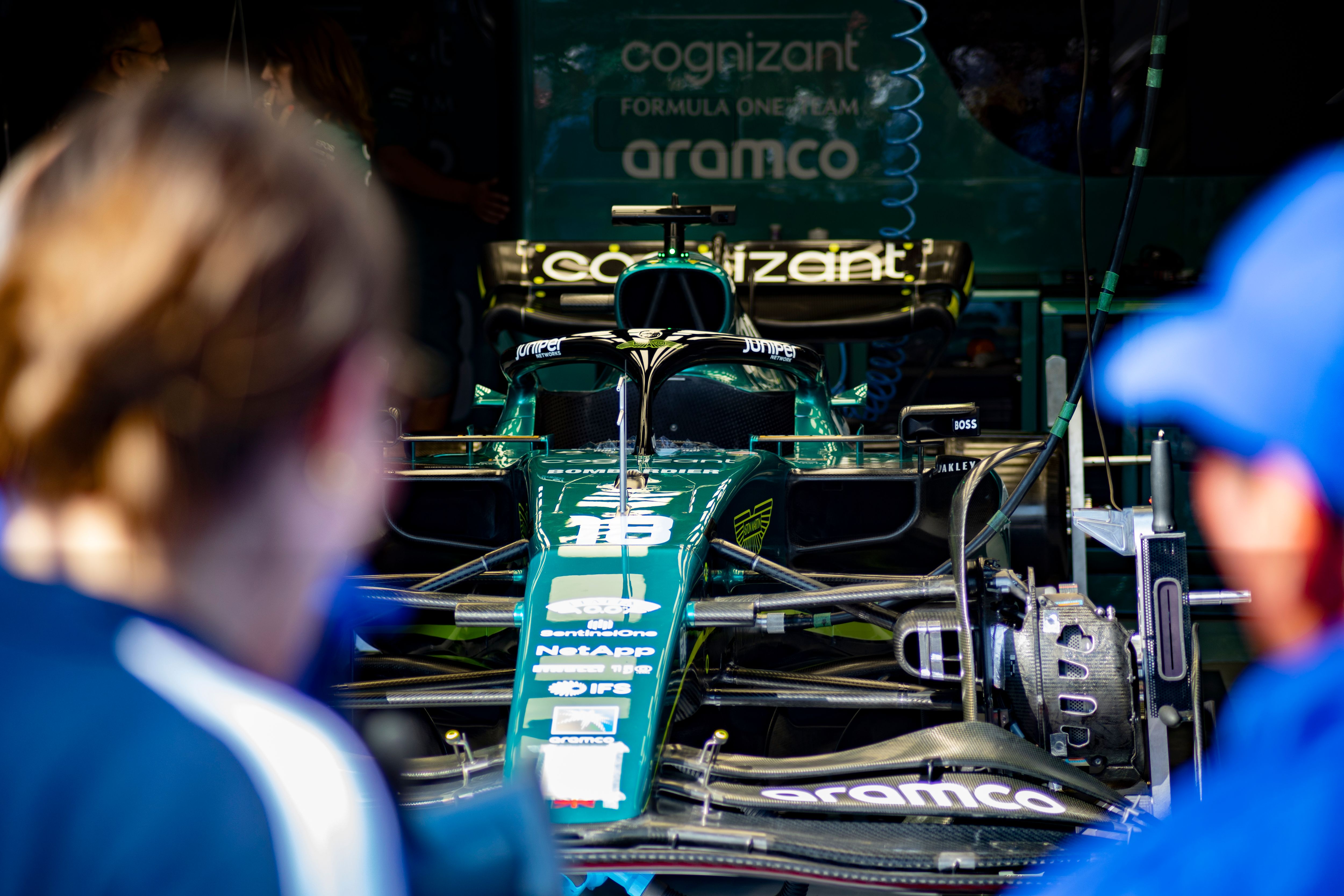 Formula 1 race car being prepared by engineers in the team garage before competition, highlighting motorsport engineering and setup work