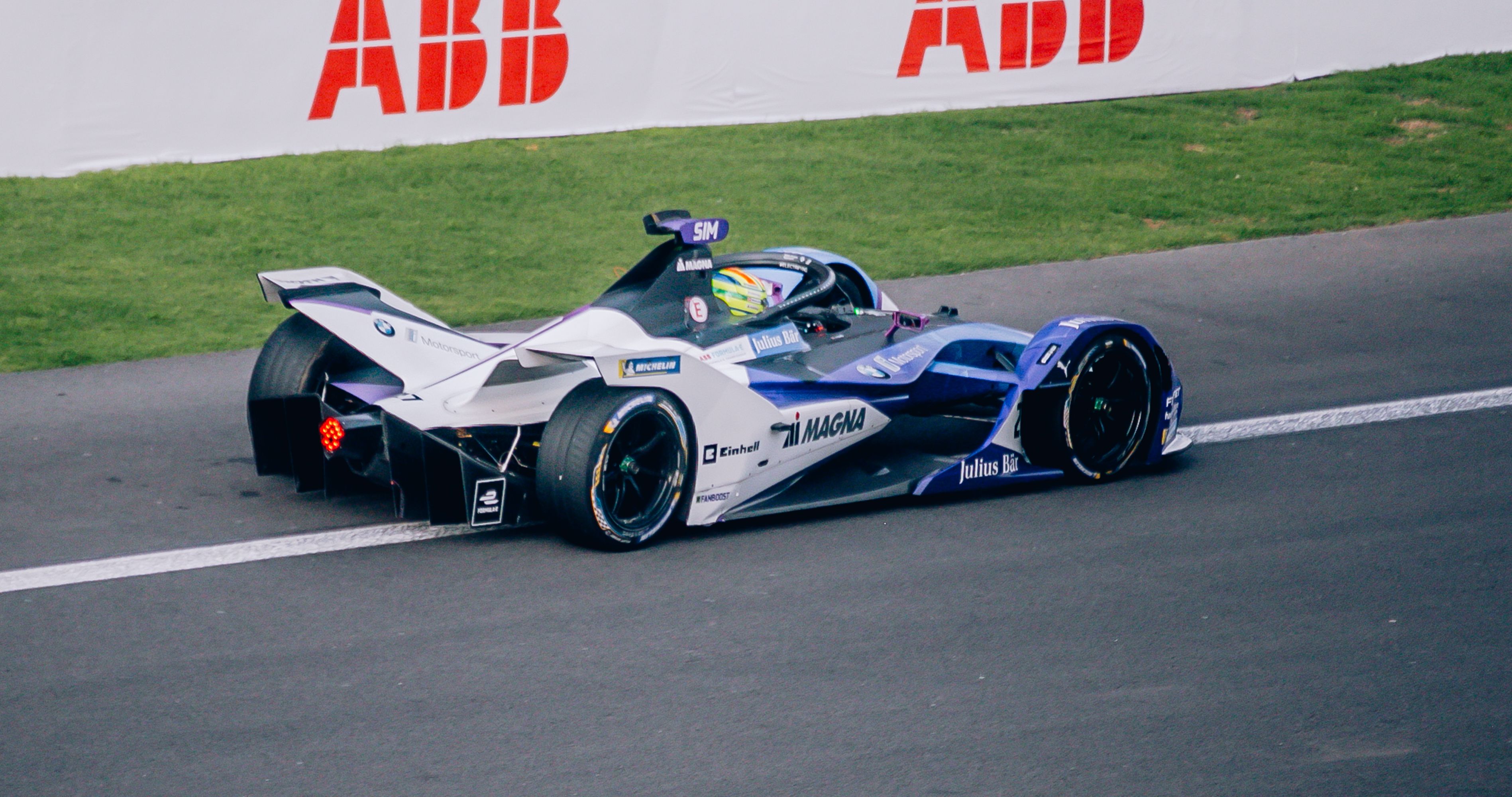 A Formula E electric race car speeding on track, showcasing the high-tech electric engineering of the series
